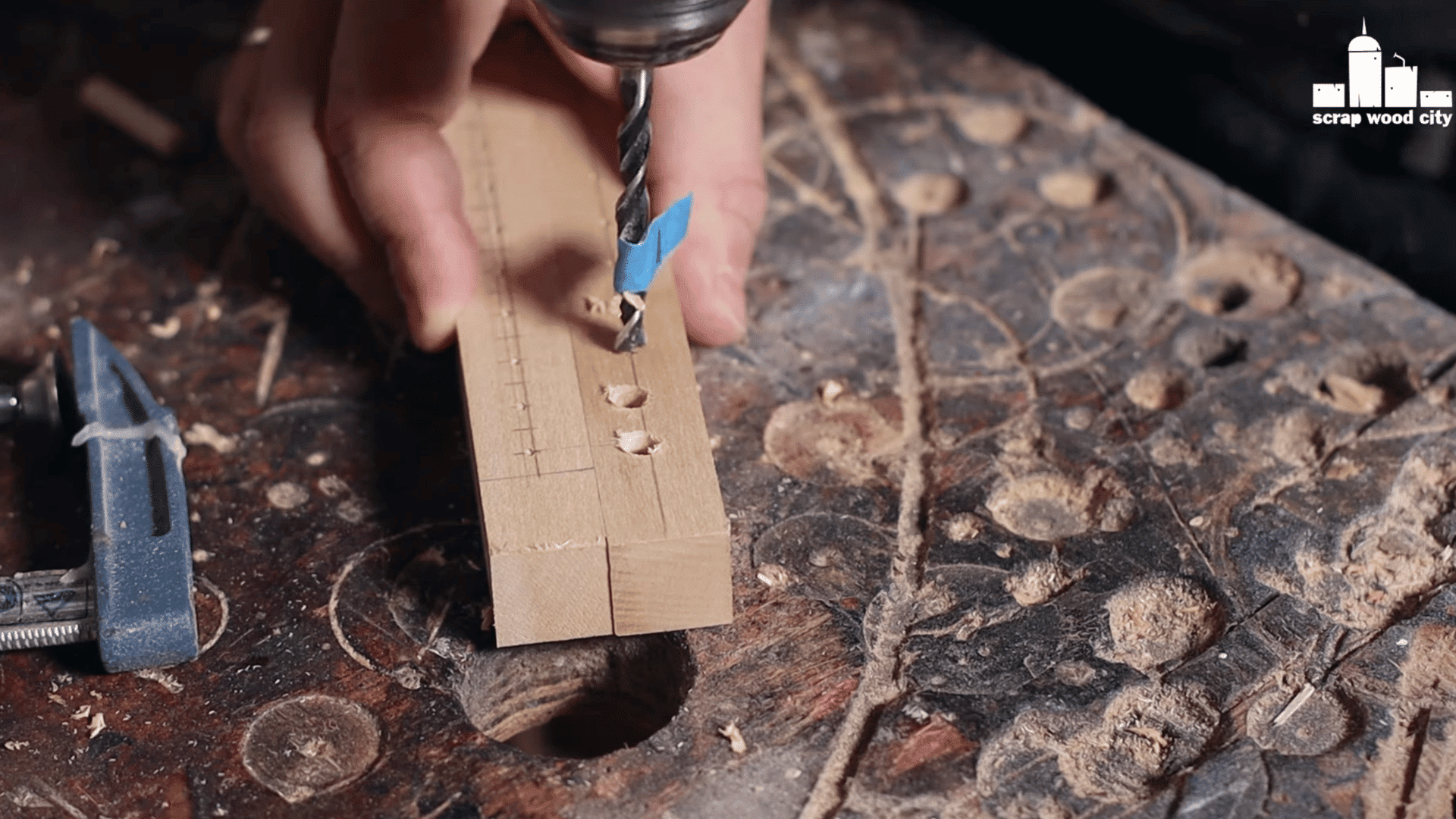 a person gluing small pegs into a wooden loom frame to hold the warp threads in place.
