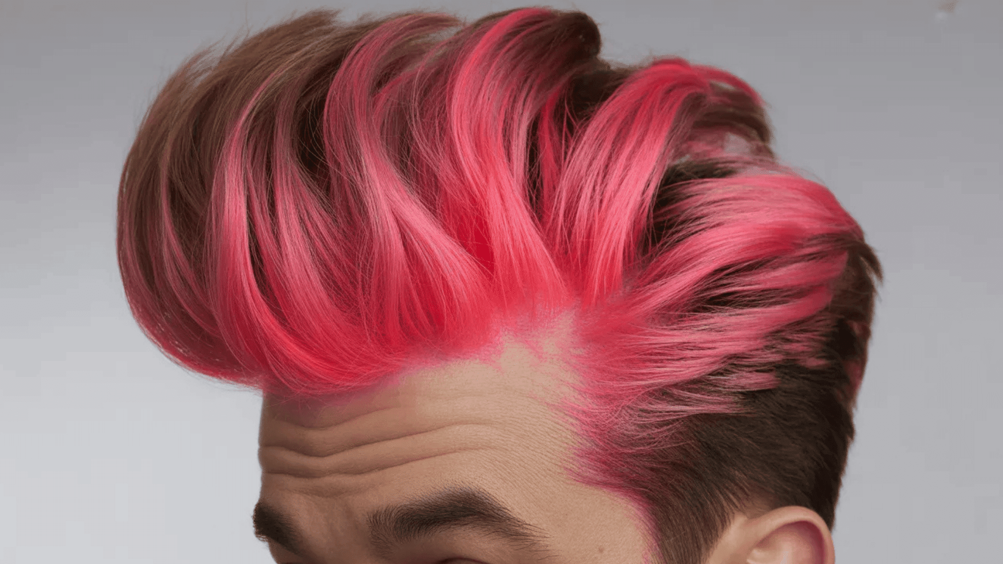 a person with voluminous, brightly colored pink hair styled upwards in a dramatic pompadour