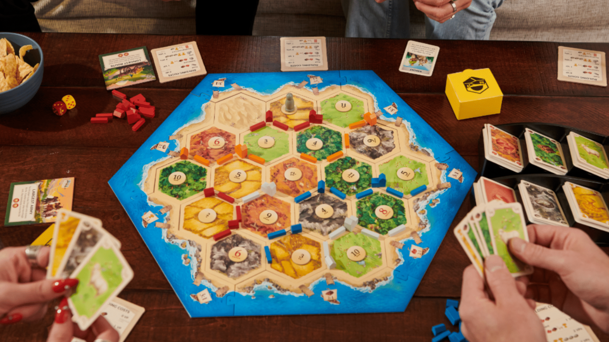 catan board game box showing the logo and artwork of players settling on an island.