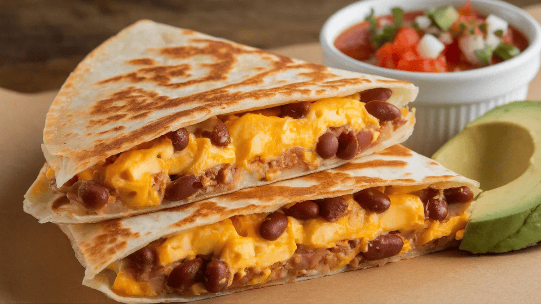 cheesy quesadilla filled with beans and cheese, served with a side of salsa and avocado slices