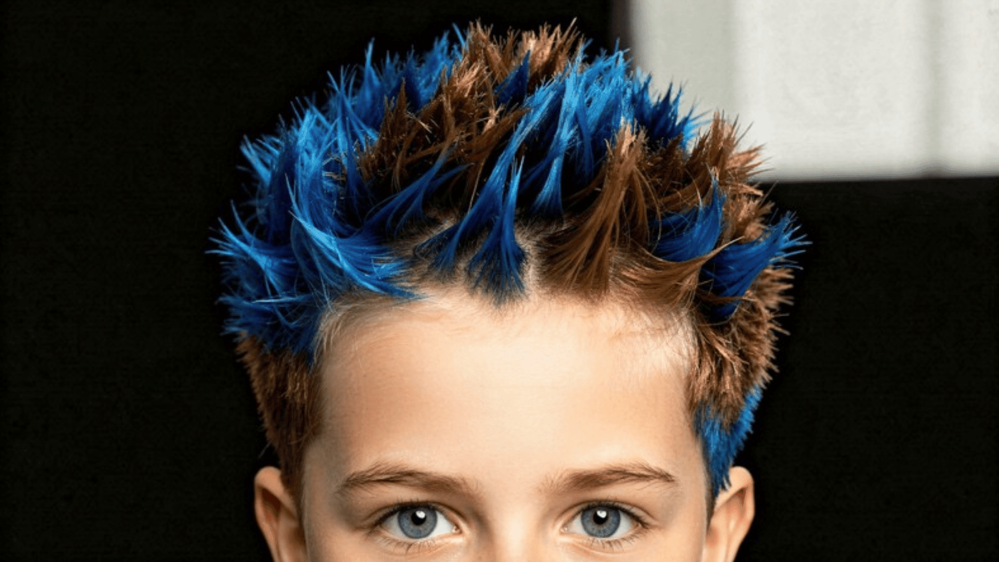 child with spiky hair dyed in blue and brown, showcasing a bold and fun hairstyle