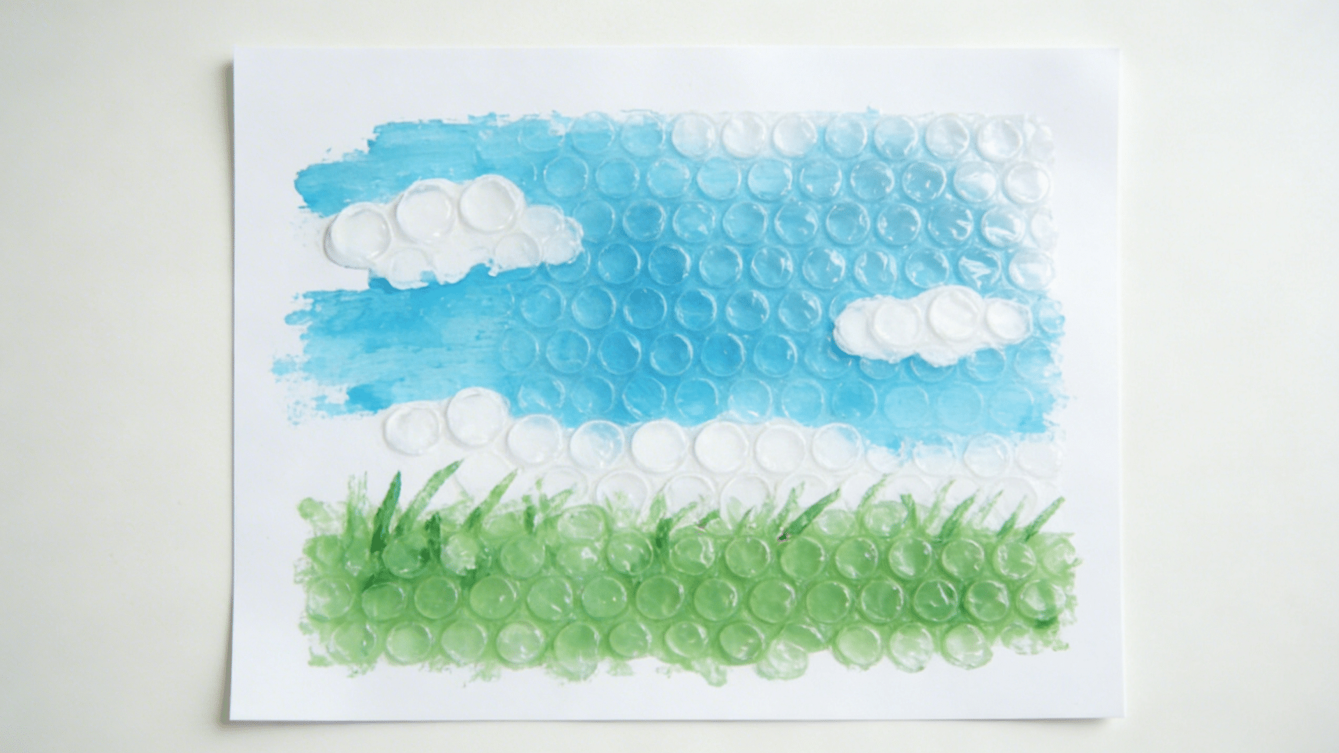 circular dot patterns printed on white paper in two colors using painted bubble wrap