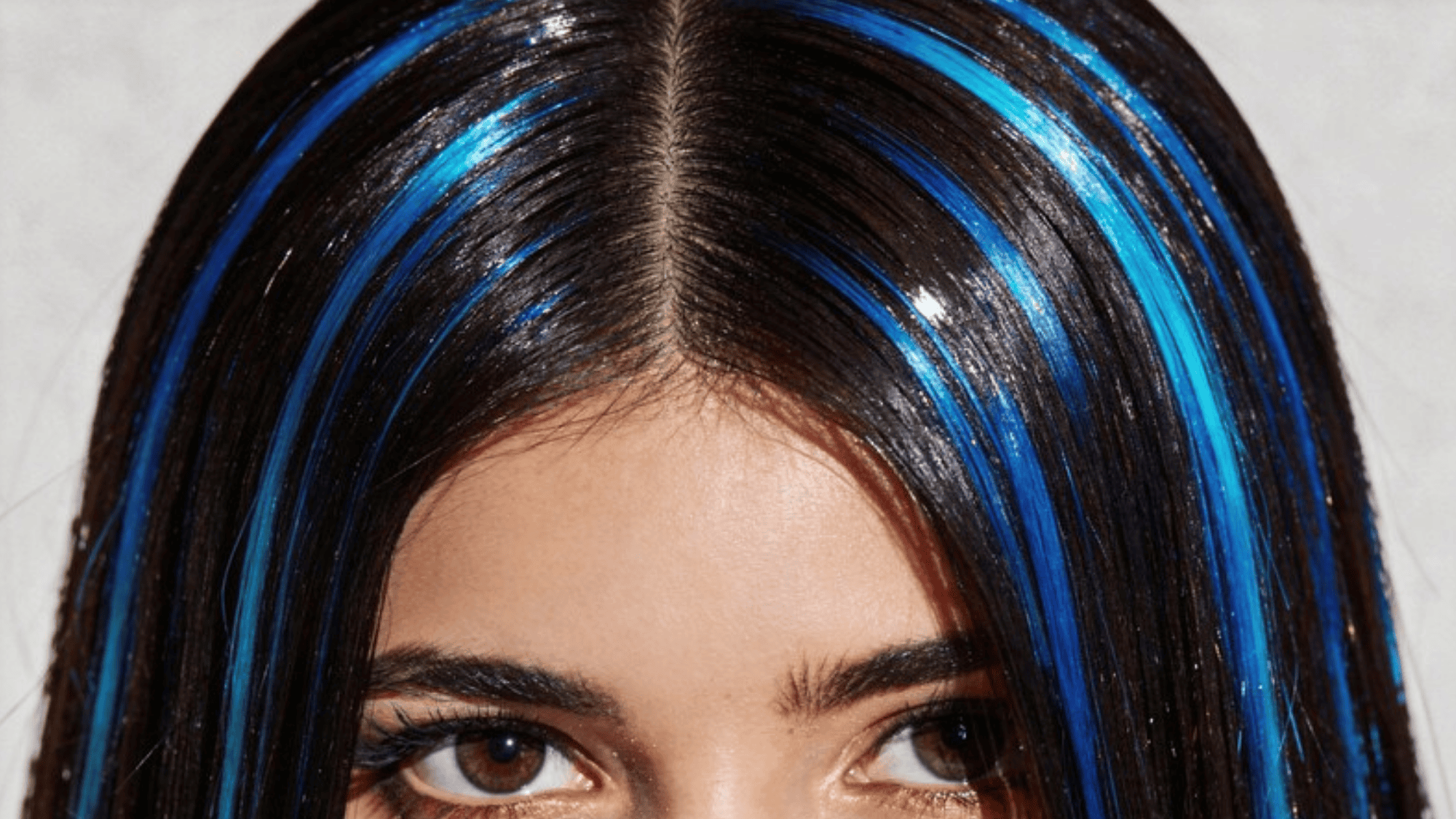 close-up of sleek hair with vibrant blue streaks, creating a striking contrast against dark, glossy strands