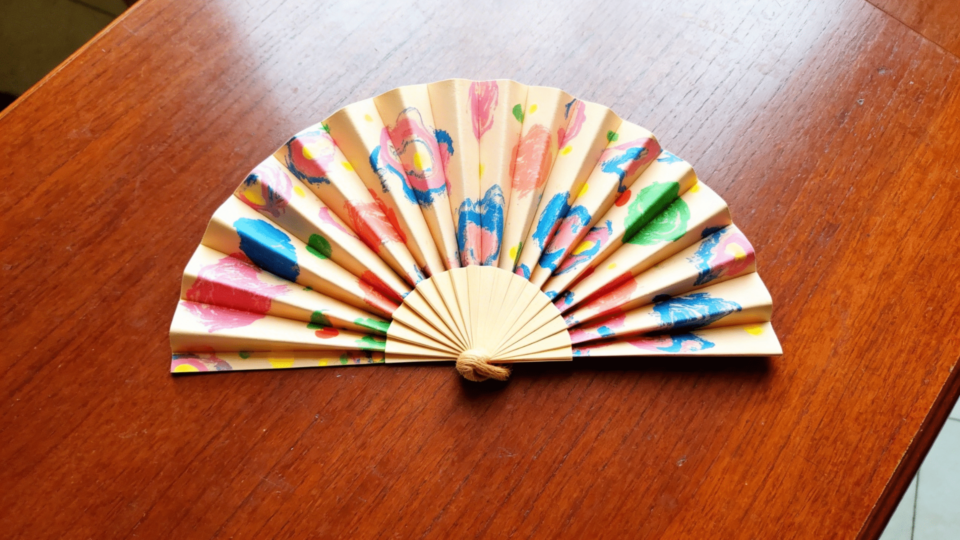 handmade paper hand fan folded accordion style with vibrant child painted decorations