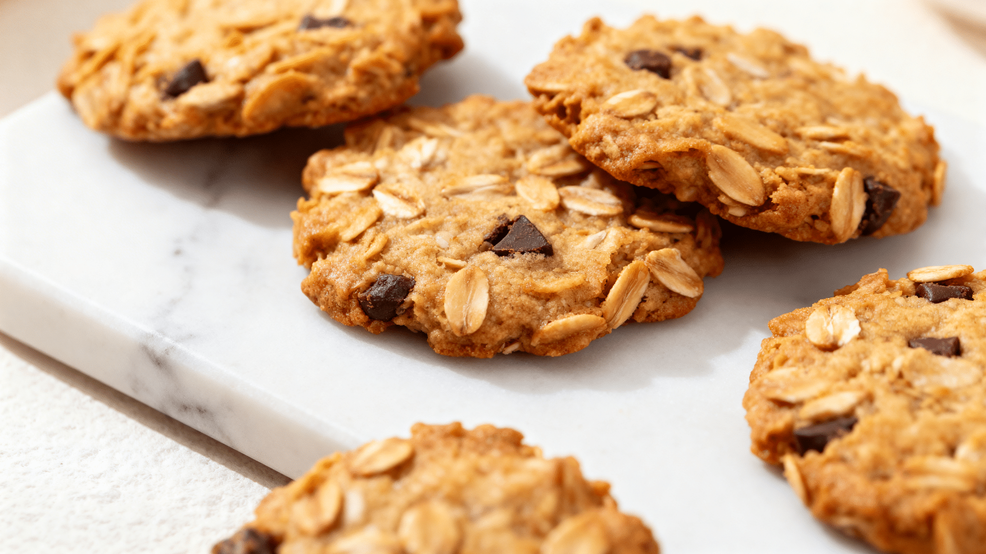 mini oatmeal cookies golden brown and stacked on a dessert tray with a soft chewy texture