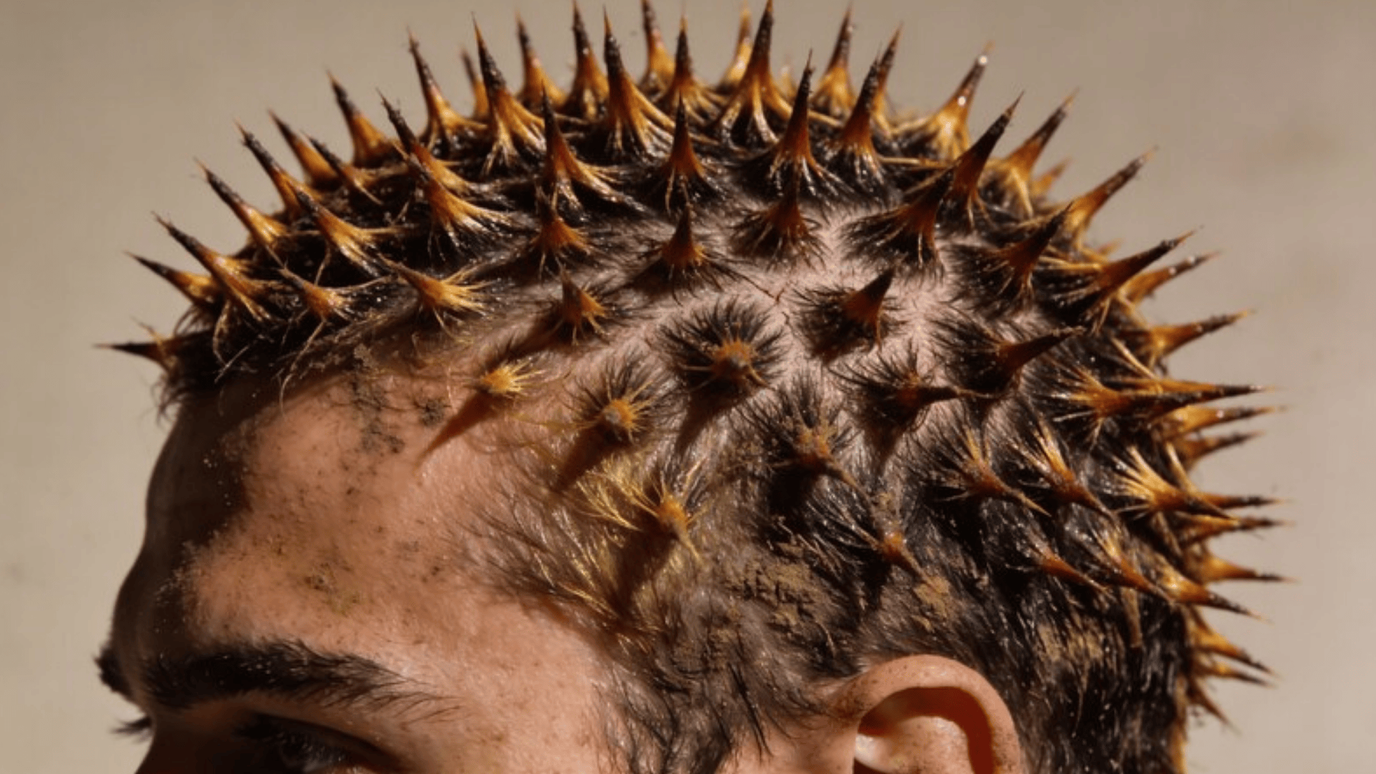 person with spiky, gelled hair styled into sharp, pointed spikes, with a textured and rugged look