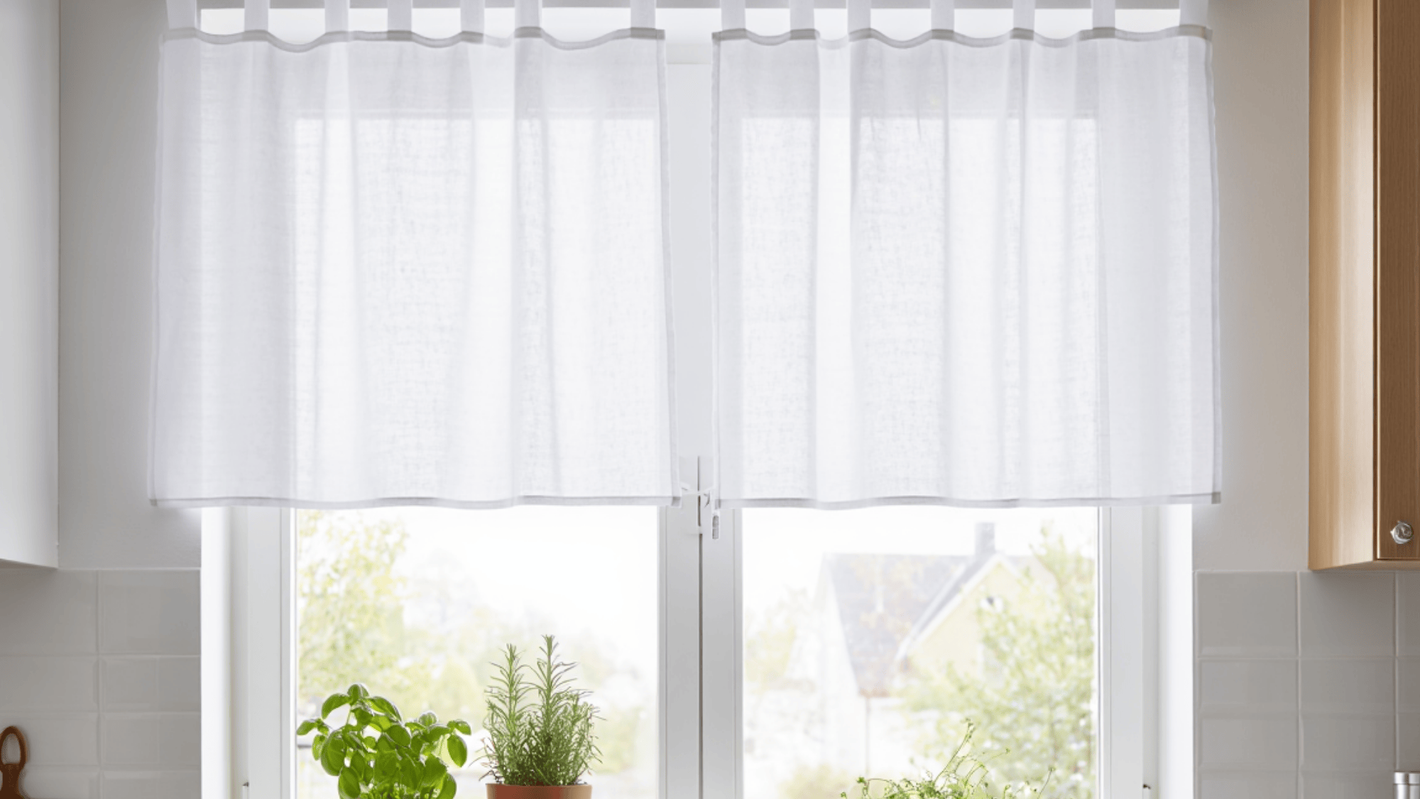 plain white tab top curtain in a kitchen and plants kept outside the window