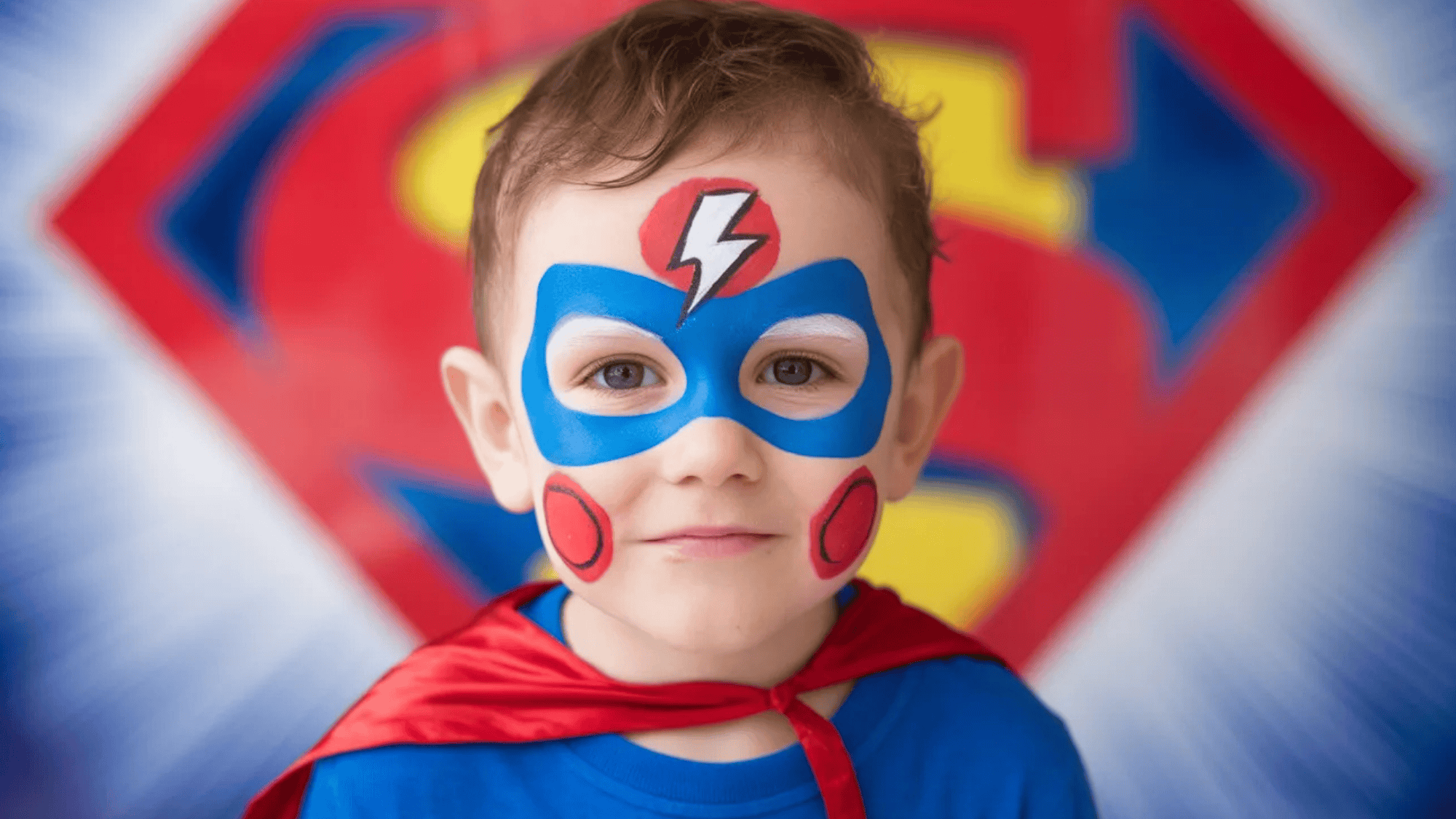 superman face paint on kid with lightning on forehead