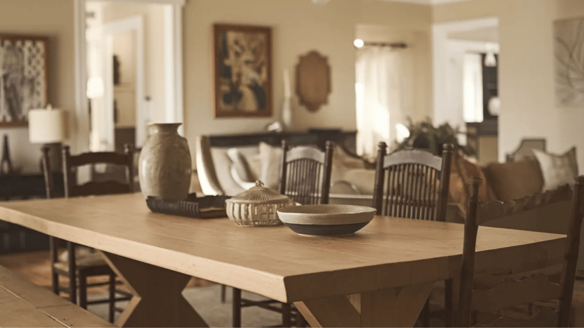 wooden dining table with simple decor, including pottery and bowls, creating a warm, inviting dining area