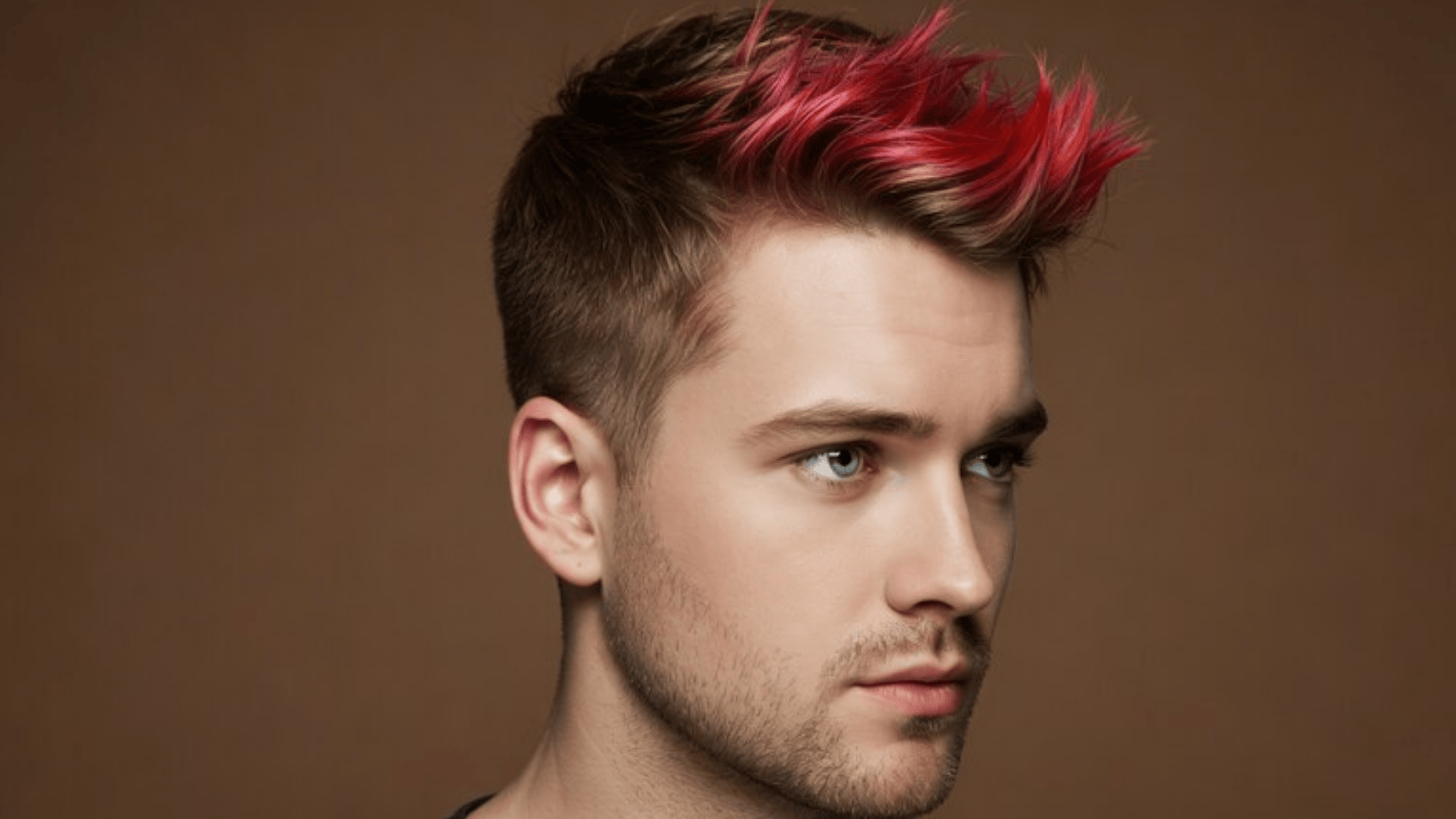 young man with styled hair featuring pink highlights, creating a bold and edgy look